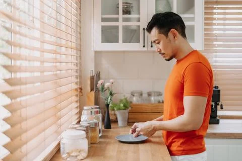 Man preparing his easy breakfast in the kitchen in warm light morning. Stock Photos