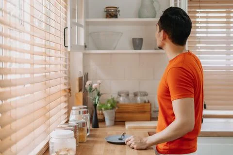 Man preparing his easy breakfast in the kitchen in warm light morning. Stock Photos