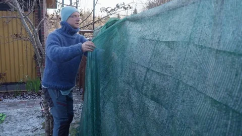 A man preparing his garden for winter on a cold frosty morning 库存影片 347362194