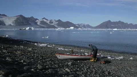 Man preparing his kayak on an Arctic beach, Greenland Stock Footage 103505495
