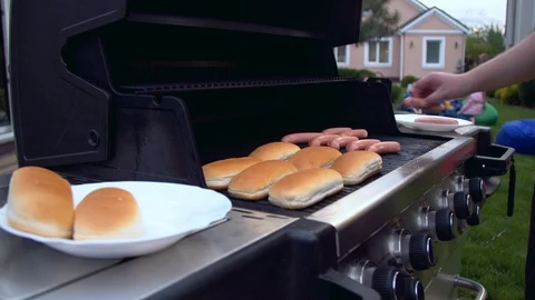 Man preparing hot dogs on a grill Stock-Footage 130058168