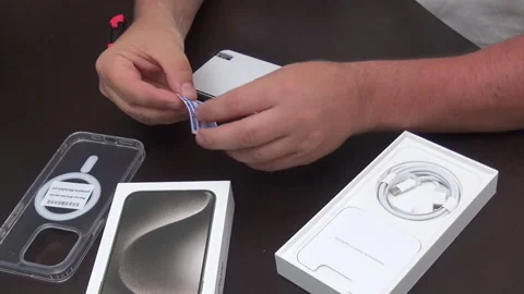 A man is preparing to install protective glass on a smartphone. Secures gla.. Stock Footage 277481827