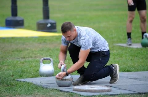 Man preparing a kettlebell for doing exercises Stock Photos
