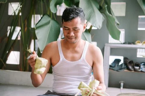 Man preparing ketupat for Eid al-Fitr celebrations at home Foto stock