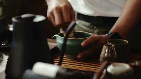 Man Preparing Matcha Tea by Whisking Green Tea in Traditional Bowl Video stock 312429117