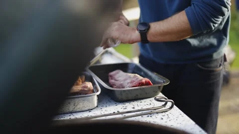 A man is preparing meat on a grill Stock Footage 295369349