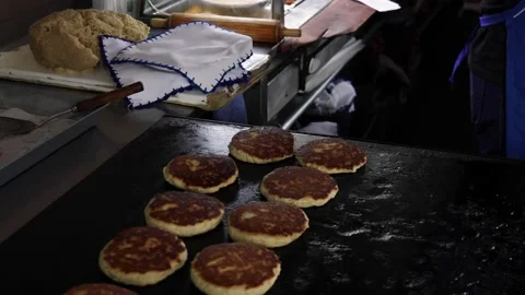 Man preparing Mexican dish called gorditas and quesadillas. Stock Footage 228082369
