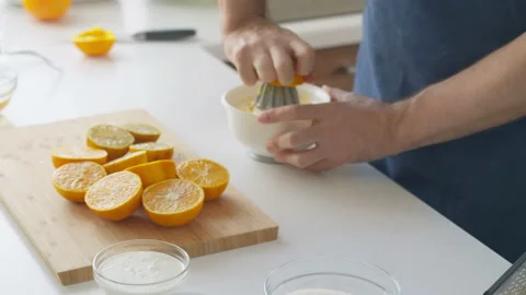 Man preparing orange juice in the kitchen Stock Footage 199209824