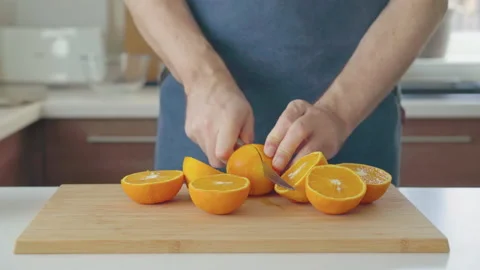 Man preparing orange juice in the kitchen Stock Footage 199211864