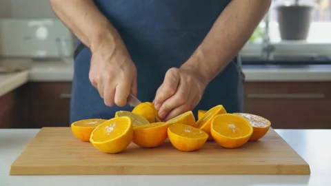 Man preparing orange juice in the kitchen Stock Footage 200715027