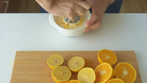 Man preparing orange juice in the kitchen Stock Footage 200715543