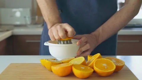 Man preparing orange juice in the kitchen Stock Footage 219677223