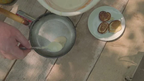 Man preparing pancakes pouring dough into hot frying pan Stock Footage 142187937