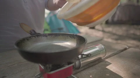Man preparing pancakes pouring dough into hot pan Stock Footage 142188035