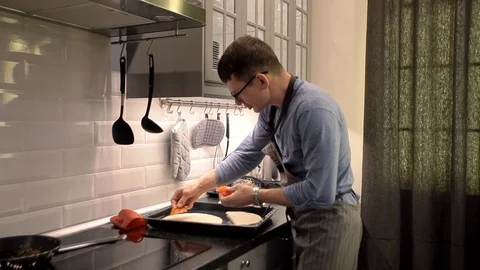 Man preparing pizza in the kitchen at home. man in glasses. ingredients. Cooking Stock Footage 72309997