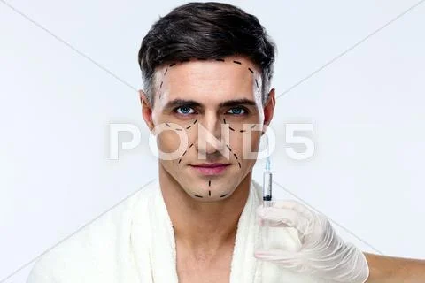 Man preparing for plastic surgery over gray background Stock Photos