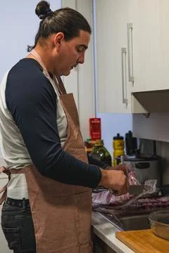 Man preparing pork ribs in kitchen for home cooking Foto stock