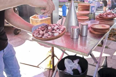 Man preparing a portion of the dish the traditional Galician octopus recipe Stock Photos