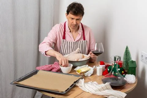 A man is preparing for a pre-Christmas dinner by baking chicken and potatoe.. Stock Photos