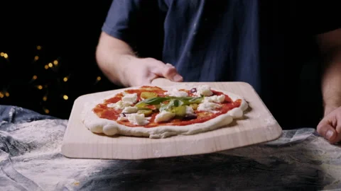 Man preparing to put pizza in the oven Video stock 132847760