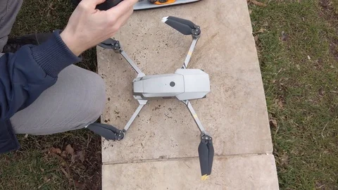 Man preparing quadcopter for take off outdoors Stock Footage 111681794