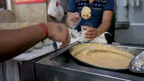 A man preparing rabri faluda glasses for his customers at a shop Stock Footage 112776907