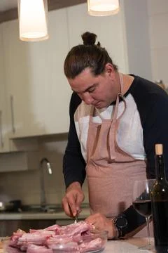 Man preparing raw pork ribs for cooking in kitchen 스톡 사진