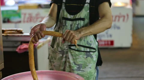 A man preparing a roll of northern Thai style sausage Stock Footage 39017957