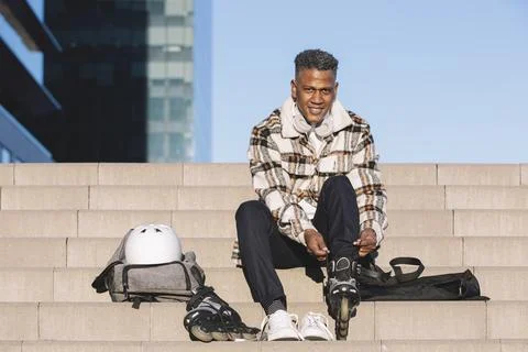 Man preparing to roller skate, putting on skates. Upright image Stock-Fotos