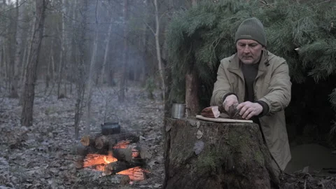 Man preparing rustic meal at forest campsite Video stock 309280301