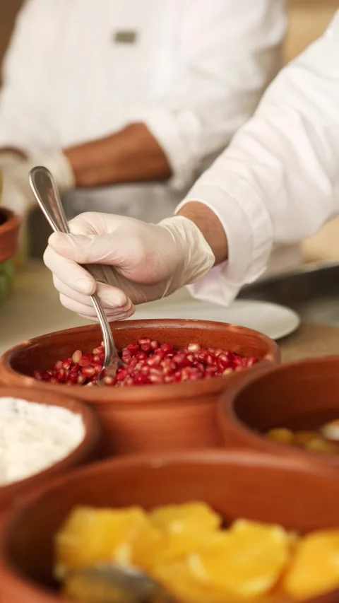 Man preparing salad bar with pomegranate seeds, food service in restaurant or Stock Footage 306544153