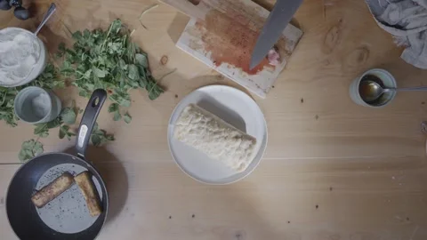 A man is preparing a sandwich on a plate Stock Footage 306043922