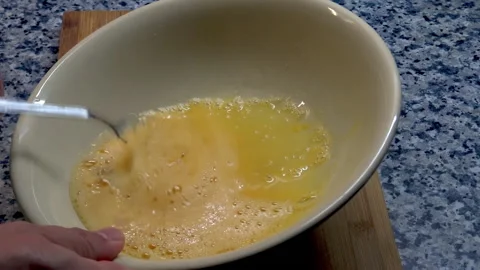 A man is preparing scrambled eggs. Stock Footage 209935820