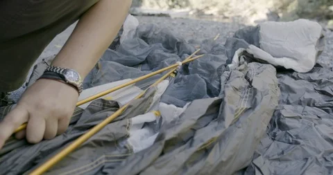 Man preparing to set up a tent in the forest Stock Footage 145277759