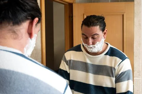 Man preparing to shave in bathroom mirror Foto stock