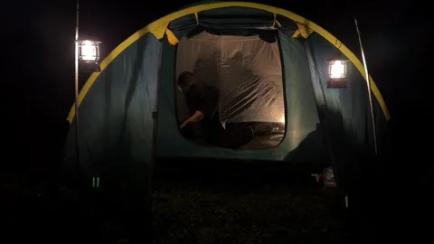 Man Preparing to Sleep in Camping Tent at Night, Static Shot Stock Footage 324502174