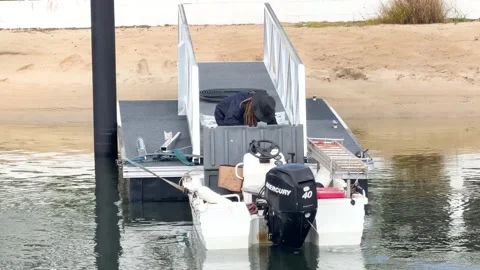 Man Preparing Small Boat for Towing at Private Pontoon Dock Stock Footage 334651701