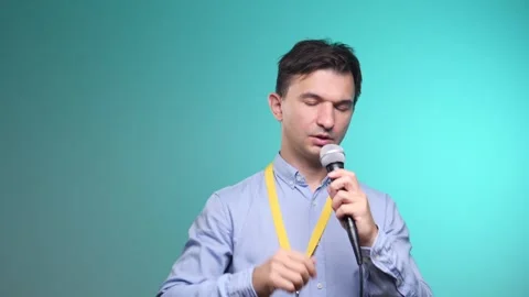 Man preparing to speak or presenting, holds a microphone with one hand and Stock Footage 342765802