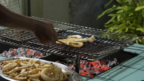 Man preparing squid rings on the grill Stock Footage 285826740