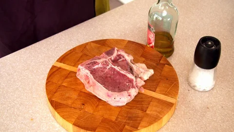 Man preparing steak in a kitchen Stock Footage 130064019
