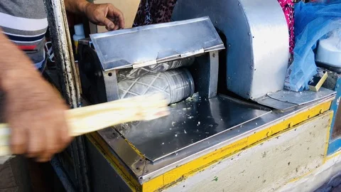 Man preparing sugarcane fresh juice in press machine Stock Footage 123633151