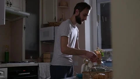 Man preparing tea for breakfast in bed, adding loose tea into a teapot 库存影片 330128661