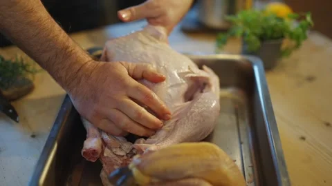 A man is preparing a turkey in a pan Video stock 295367611