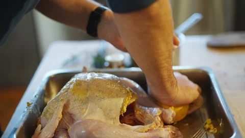 A man is preparing a turkey in a pan Video stock 295368099