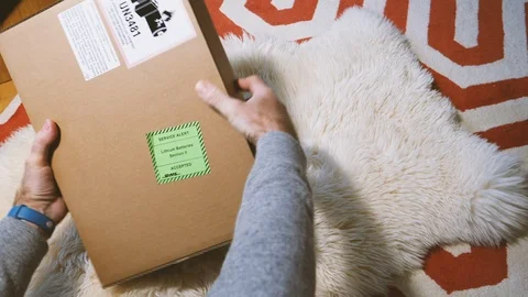 Man preparing to unbox unpack cardboard box delivered by DHL Stock Footage 100450157