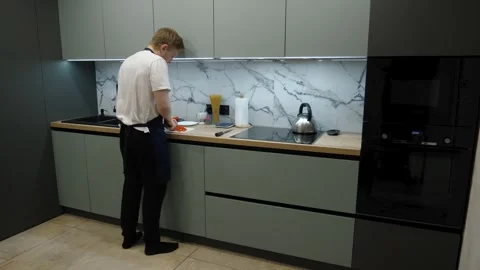 Man is preparing various ingredients in a modern kitchen Stock Footage 311599828