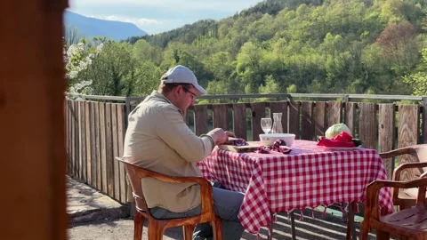 Man Preparing Vegetables at Rustic Outdoor Table with Scenic View Stock-Footage 333523421