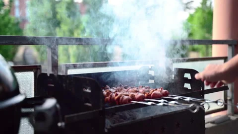 Man preparing weekend lunch outdoors for family, roasting meat skewers on Stock Footage 132695915