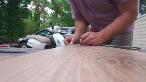 Man preparing wooden plank for DIY home improvement project. white oak laminate Stock Footage 340566065