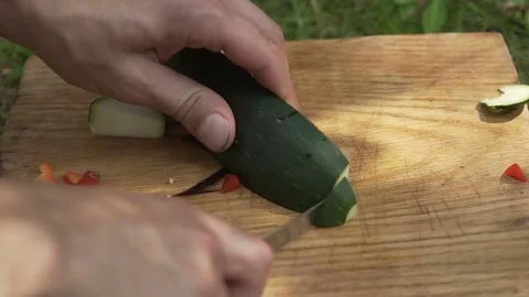 Man preparing zucchini in the open air Видео 80240734